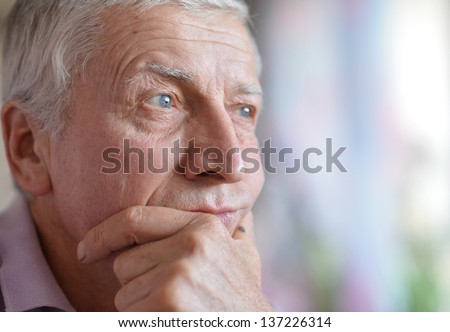close-up portrait of a senior man thinking about something