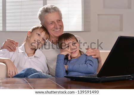 Portrait of two boys and old men with laptop at home