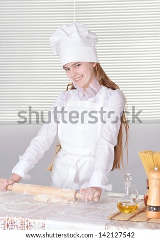 cute little girl knead the dough for the cake