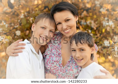 happy mom with her two sons rest on the nature