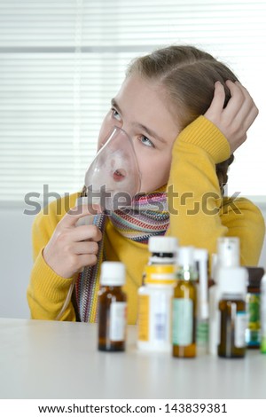 Portrait of a young girl in a yellow sweater takes medicine