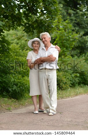 happy Mature couple walks in the park in summer day