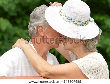 happy old couple walks in the park in summer day