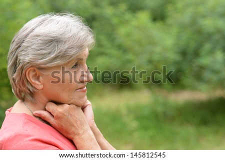 happy elderly woman enjoying a walk in the fresh summer air