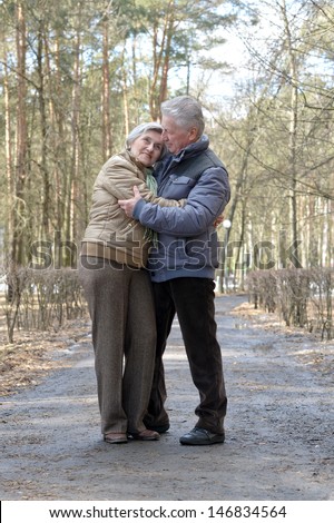happy elderly couple on a walk in the forest in the spring