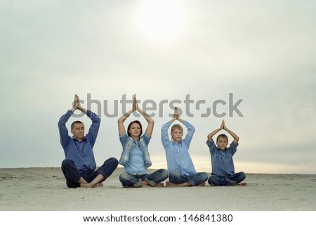 family of four people doing yoga on the fresh air
