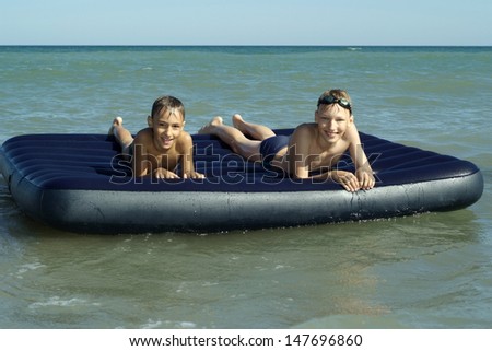 two little boys floating on air mattress