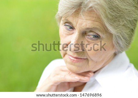 Portrait of an aged woman on a walk in the park in late spring