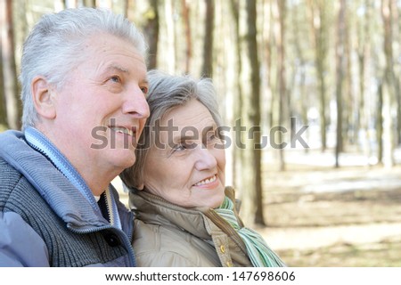 happy elder couple on a walk in the forest in the spring