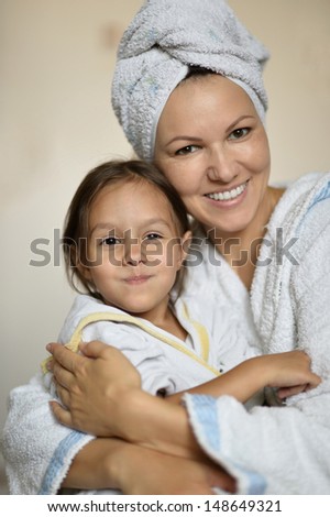 Mom and her little daughter in white bathrobes