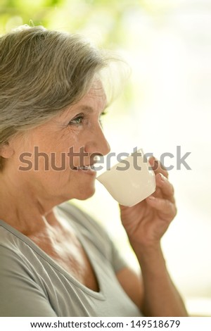 elderly woman in a gray T-shirt at home