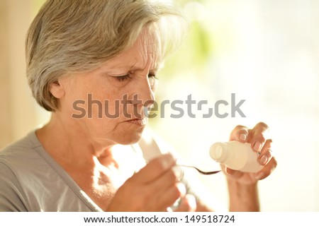 elderly woman in a gray T-shirt at home