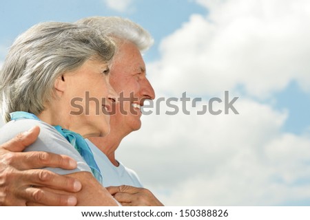Happy elderly couple on a sky background