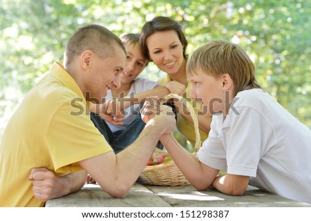The family at the table. Father and son arm wrestling fight