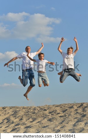 Happy family of three people jumping outdoors