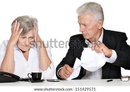 Older stressed couple in the workplace on a white background