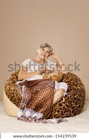 Senior lady knitting sitting at home