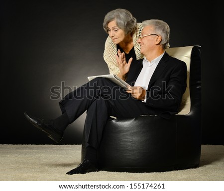Fashionable elderly couple in studio on black background