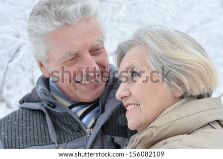 Happy senior couple standing in winter outdoors