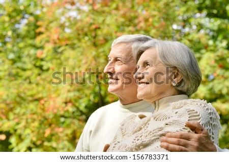 Happy senior couple standing in autumn park
