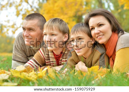 merry happy family on a walk during the fall of the leaves in the park
