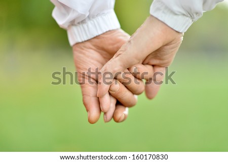 Concept shoot of friendship and love of man and woman: two hands over nature