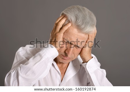 Portrait of sad elderly man on grey