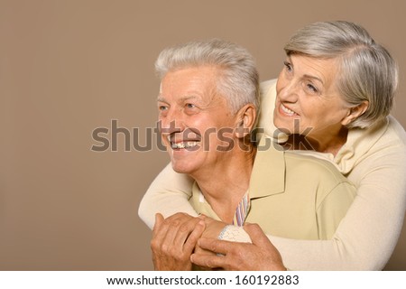Close-up portrait of a happy senior couple on grey background