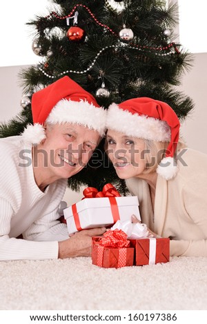 Happy beautiful elderly couple celebrating new year at home