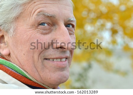 Portrait of a nice old man posing at nature