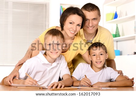 Happy family drawing at the table together