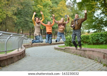 Happy family jumping in autumn  park