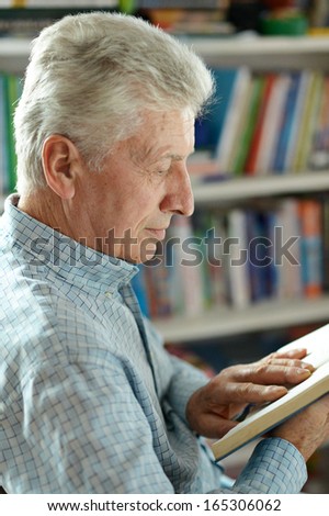 Senior man in library with book