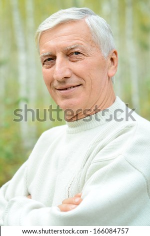 Portrait of a nice old man posing at nature