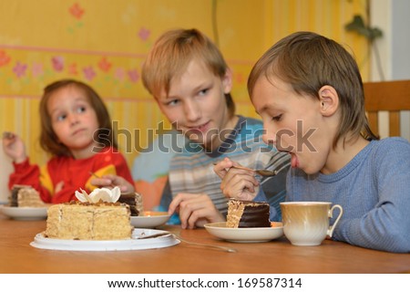Brothers and sister eating cake at home