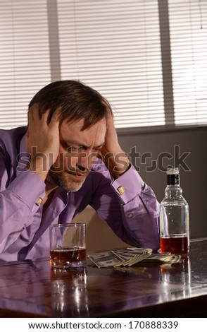 Cute young man drinks whiskey at table