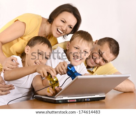 Happy family with computer on a floor