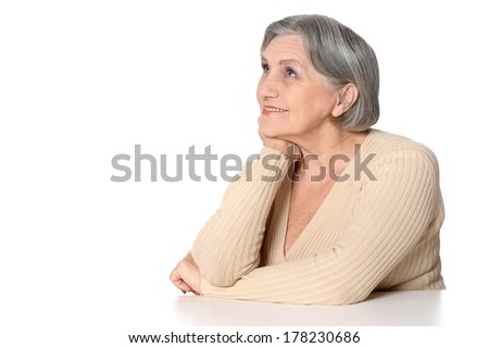 Portrait of thinking and smiling elderly woman on white background