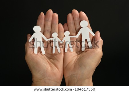 Paper  family in hands  on dark background