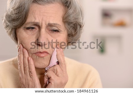 Elderly nice woman having bad tooth pain