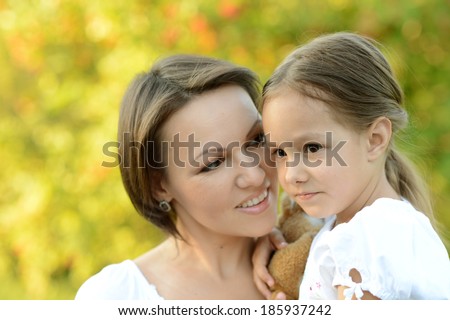 Happy mother with her daughter walk in the park in summer
