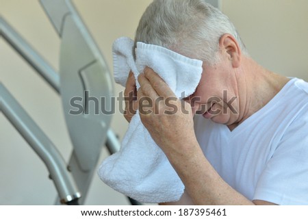 Elderly man in a gym with towel
