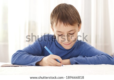 Boy drawing felt pen on white paper