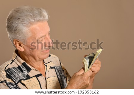 Happy old man with dollars on background