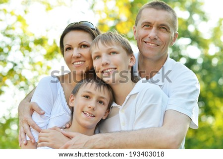 Happy family in the green in a summer park