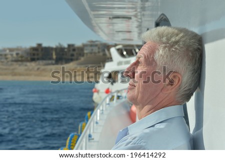 Amusing elderly man have a ride in a boat on sea