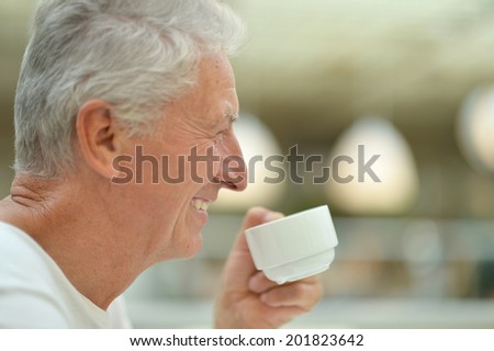 Portrait of beautiful happy elderly man drinking tea