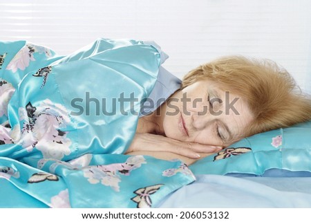 beautiful older woman sleeping in bed at home