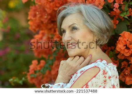 Portrait of a beautiful smiling elderly woman with flowers