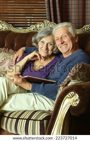 Senior couple on the couch with book